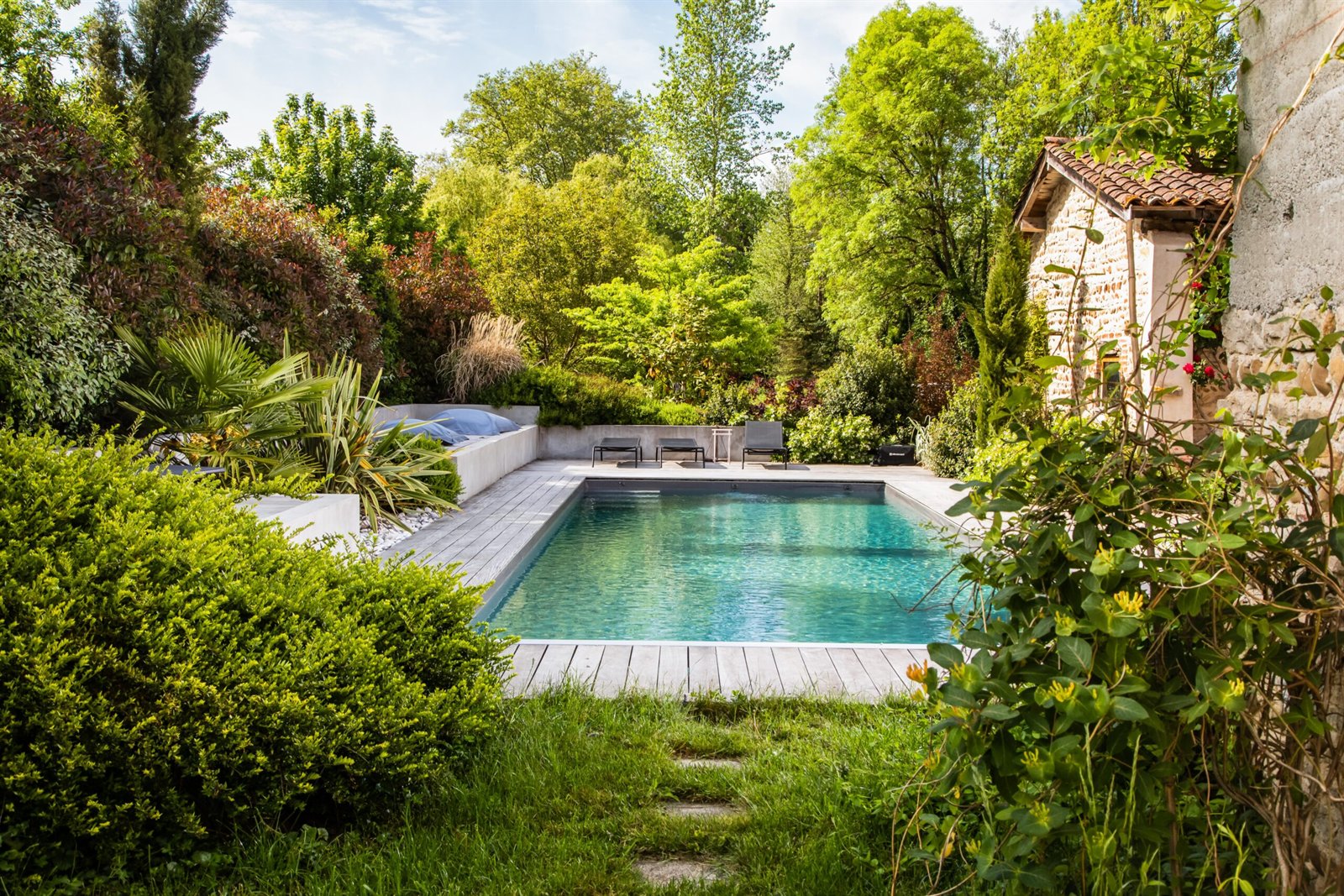 Création de jardin paysagé avec piscine et bordures végétales — réalisation Pépinière Mainaud